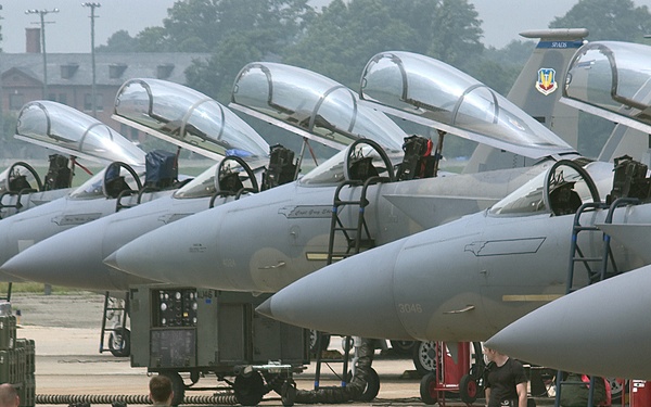 Air Force Capt. Matt Johnson and Tech. Sgt. Ben Bloker walk the flight line to a F-15 Eagle.