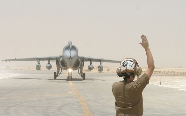 Navy Airman Broquel Schaefer signals the pilot of a Navy EA-6B Prowler.