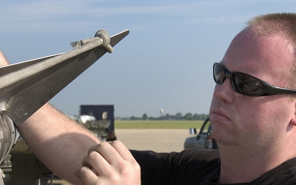 Air Force Staff Sgt. Jason Larkins inspects a AIM-9 Sidewinder missile.