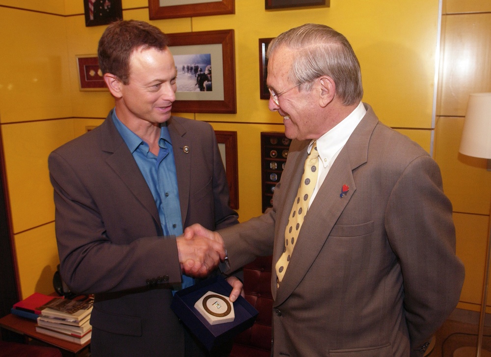 Secretary Rumsfeld presents actor Gary Sinese with an inscribed limestone Pentagon.