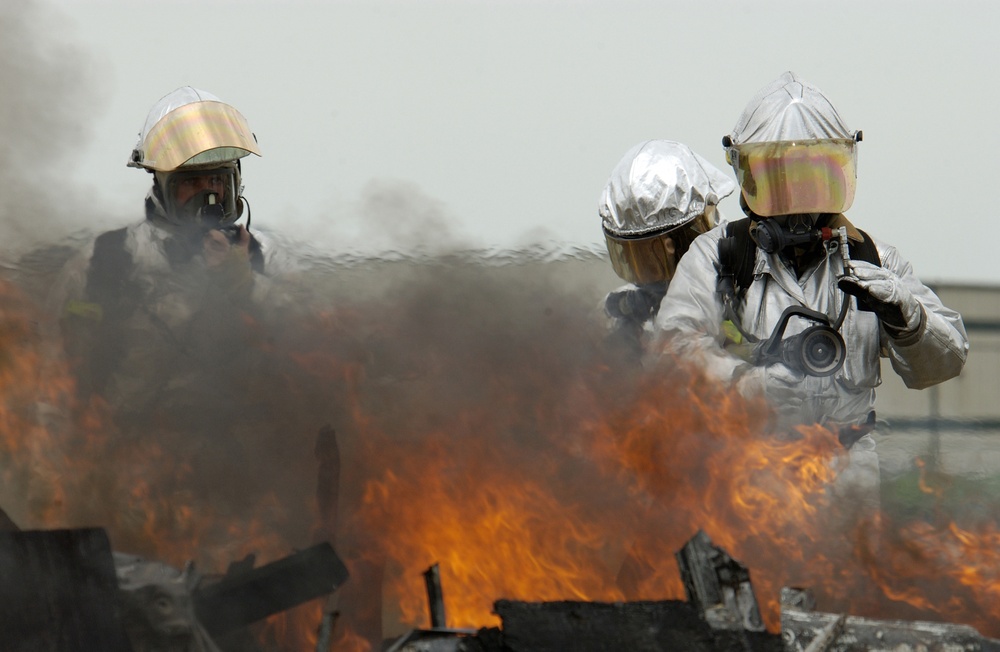 Iowa U.S. Air National Guard firefighters approach a fire in a simulated aircraft.