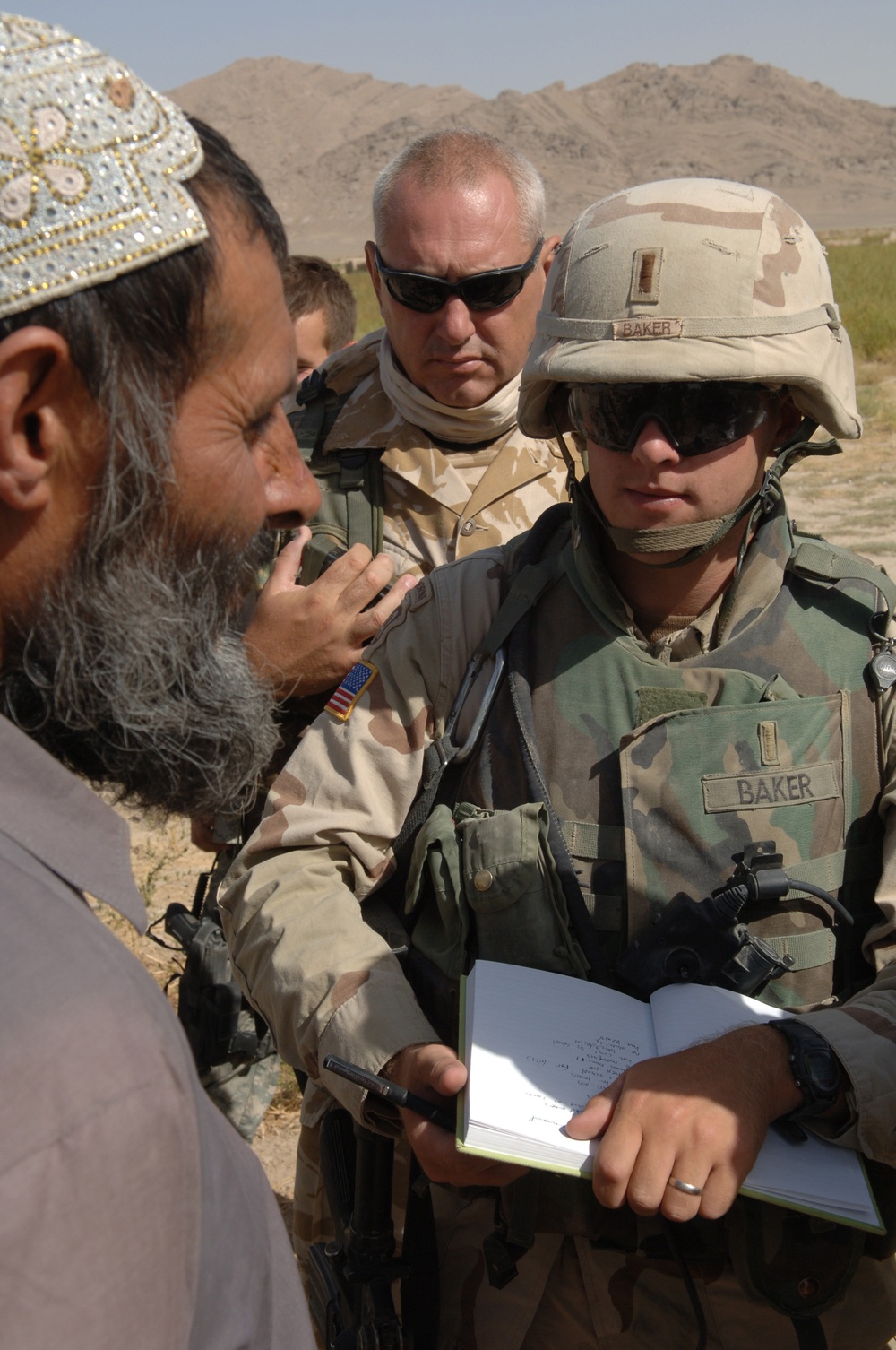 Army 1st Lt. Greg Baker listens as the village elder talks to him.