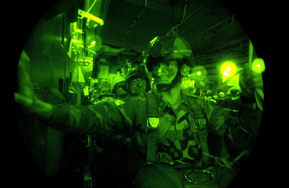 Paratroopers are hooked up as they prepare for a nighttime static line jump.