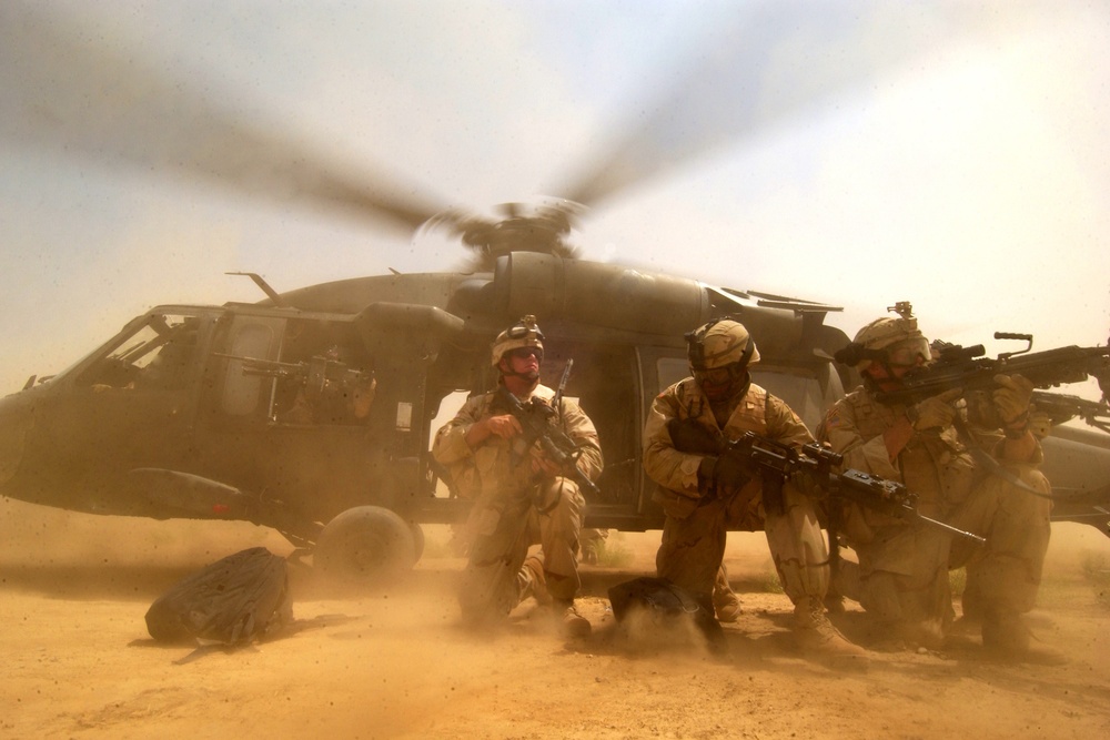 The rotor wash of a UH-60 Black Hawk helicopter kicks up clouds of dust.