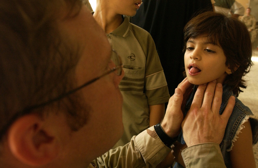 Army Capt. Jeremy Orr examines the throat of an Iraqi girl.