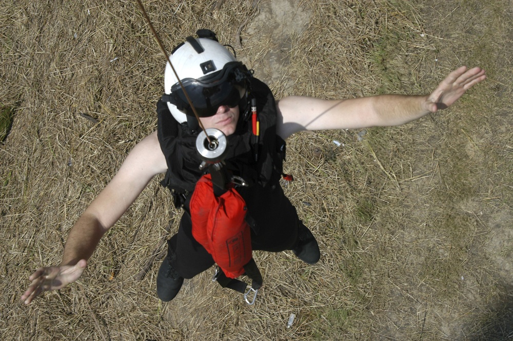 A Navy Search and Rescue swimmer is hoisted back on board a MH-60S Seahawk helicopter.