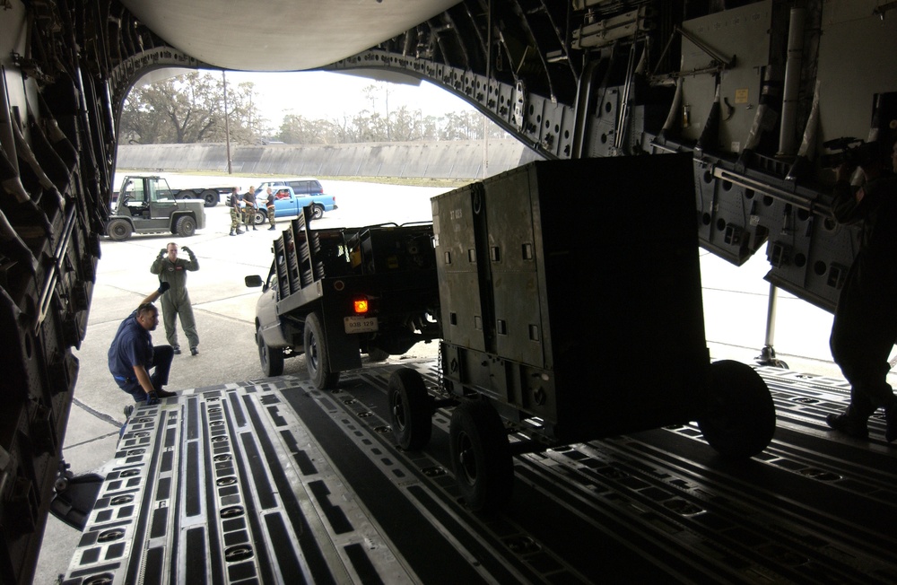 U.S. Air Force personnel off load a generator from a C-17 Globemaster III aircraft.