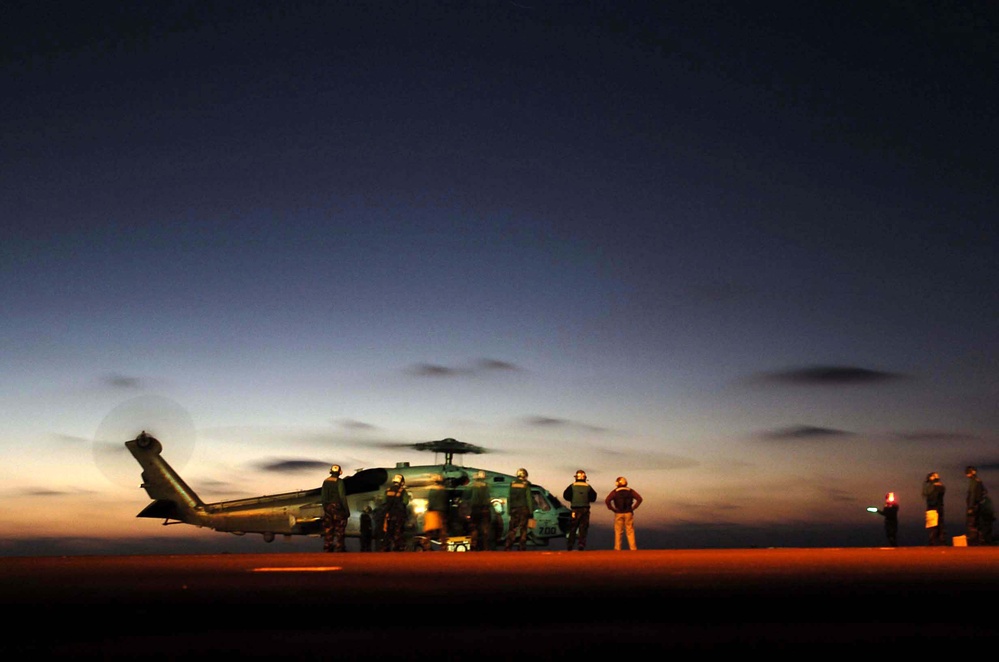 An SH-60B Seahawk helicopter refuels during plane guard duties.