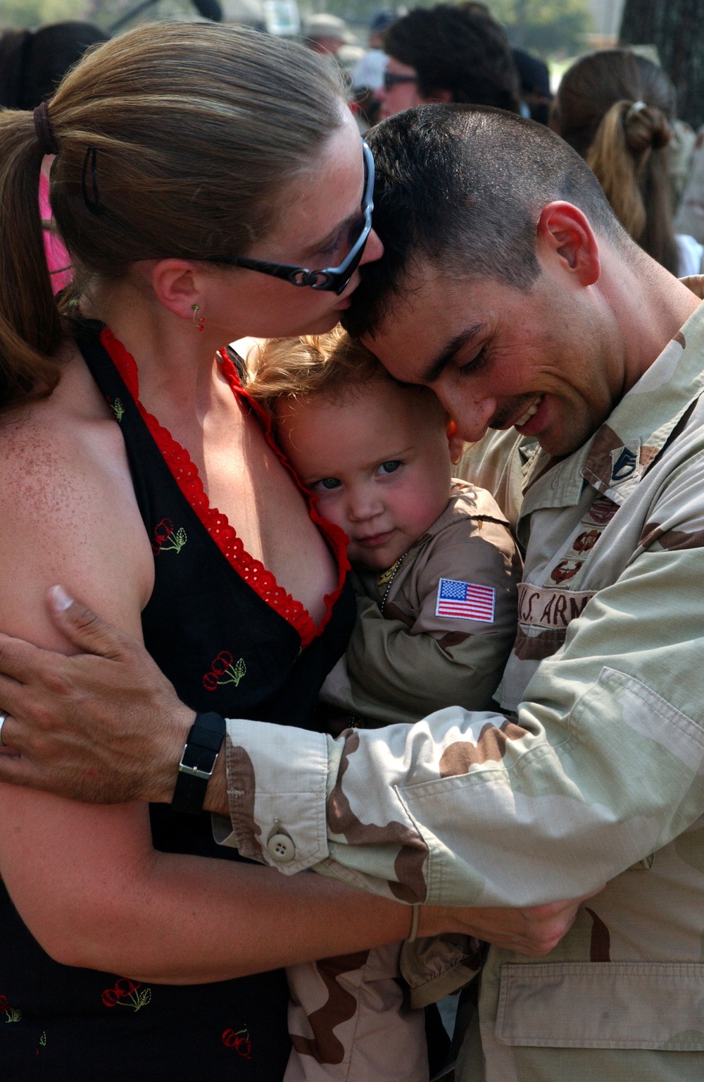 U.S. Army Staff Sgt. Tommy McGee hugs his wife and daughter.