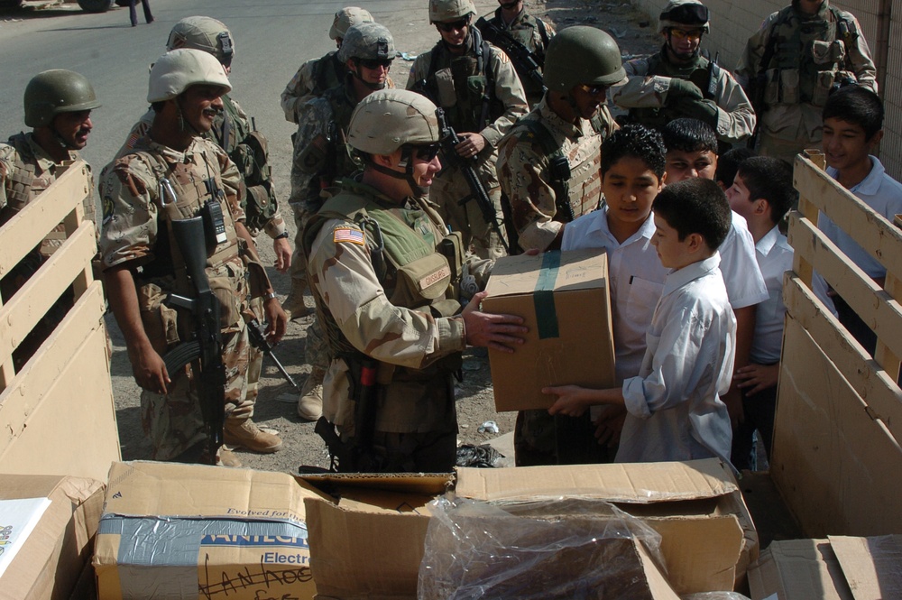 U.S. Army soldiers and Iraq Army soldiers drop off school supplies.