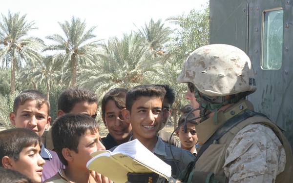 U.S. Marine Corps Cpl. Ross Casey attempts to communicate with local children.