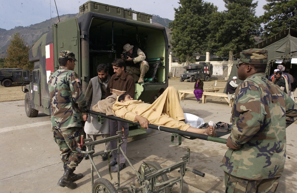 Members of the U.S. Army's 212th Mobile Army Surgical Hospital load a Pakistani woman into a ambulance.