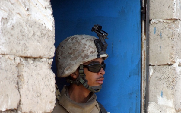 U.S. Marine Corps Lance Cpl. Hector Figueroa takes up a position in a doorway.