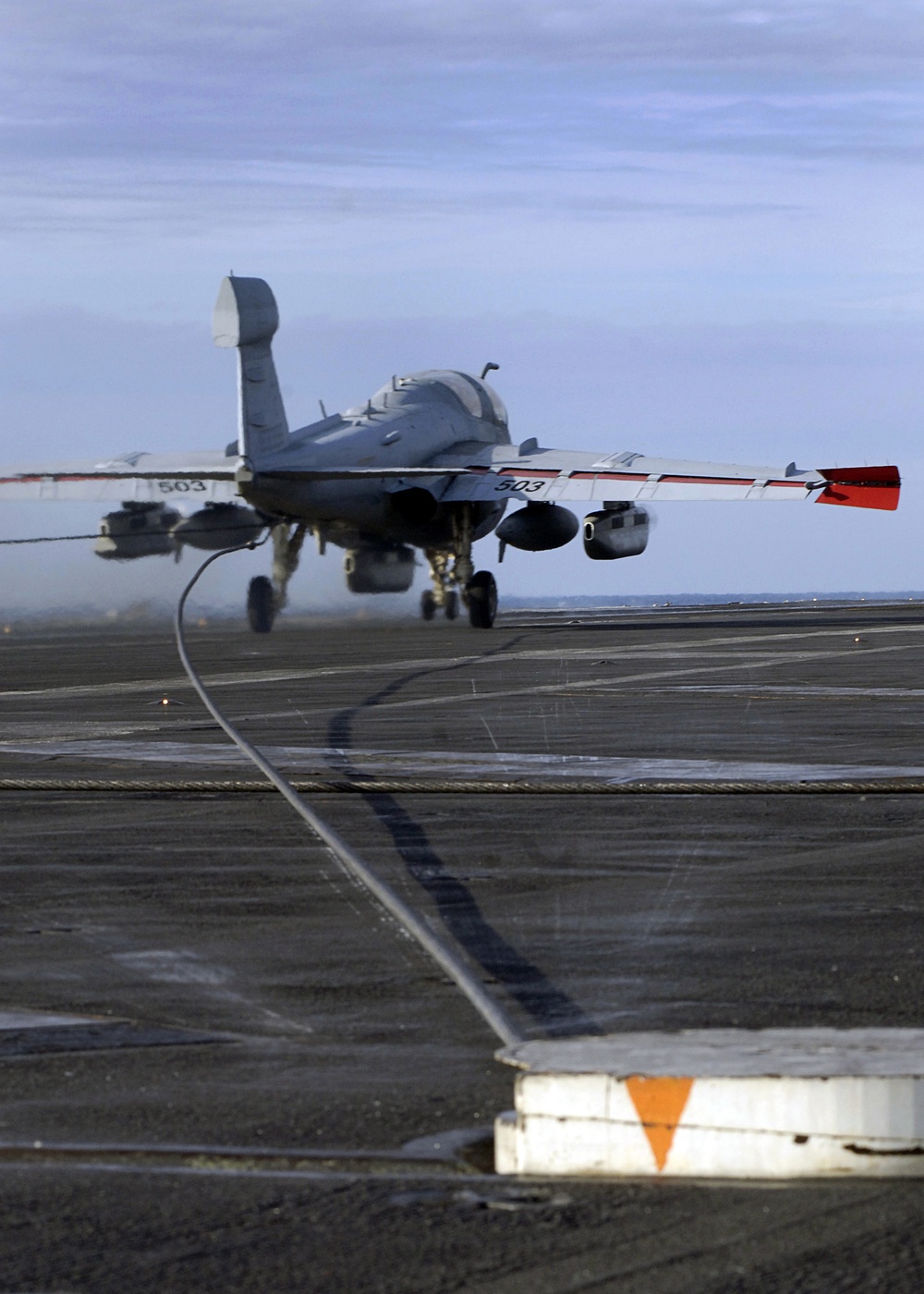 An EA-6B Prowler aircraft catches the arresting wire on the flight deck.