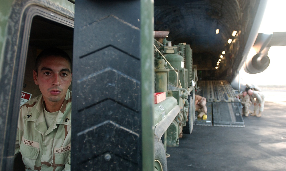 Army Sgt. Weston Berg watches flight crew members in his mirror.