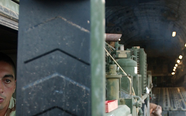 Army Sgt. Weston Berg watches flight crew members in his mirror.