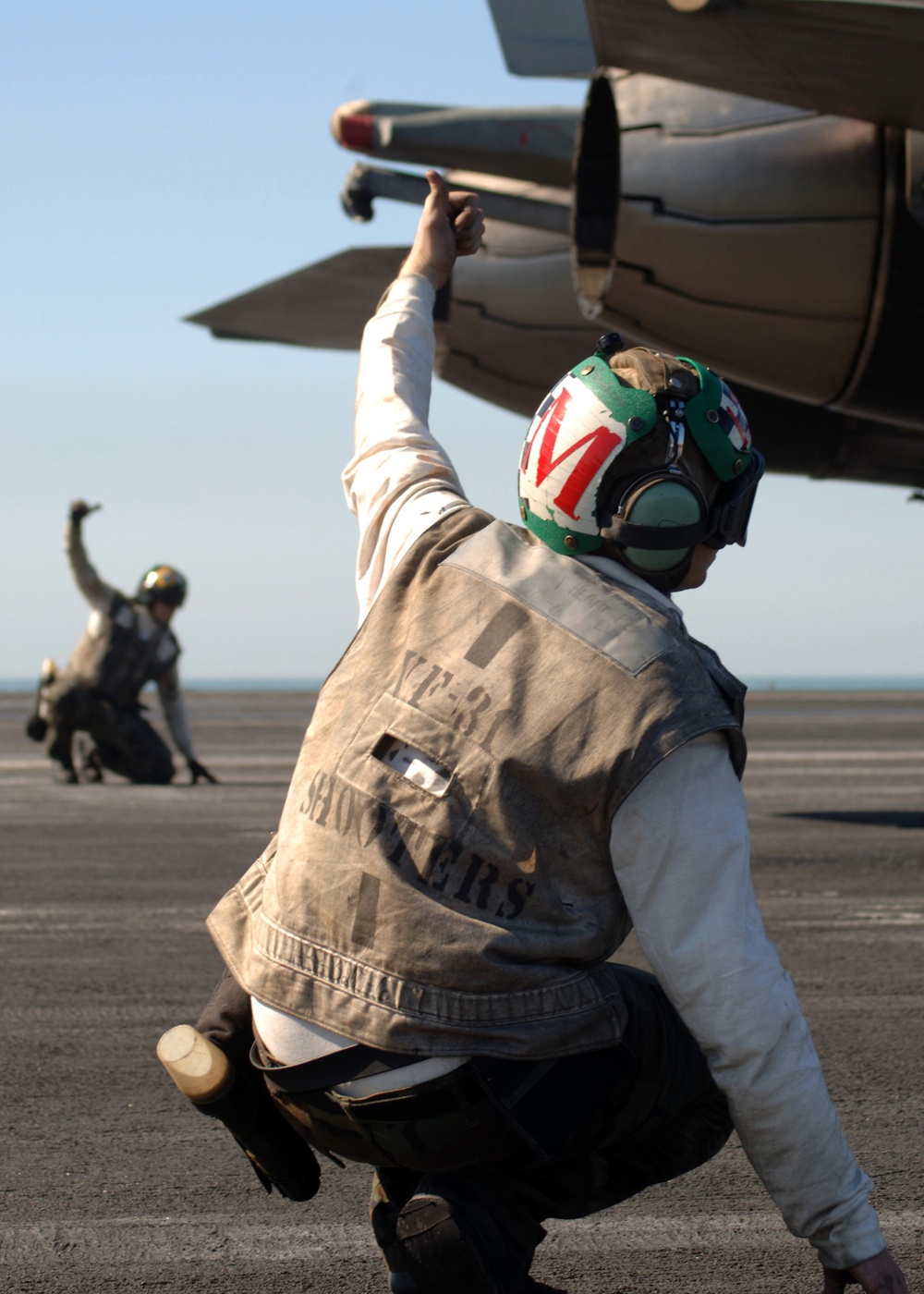 Flight deck crew members assigned to Fighter Squadron 31 give a thumbs up.