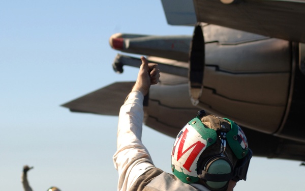 Flight deck crew members assigned to Fighter Squadron 31 give a thumbs up.