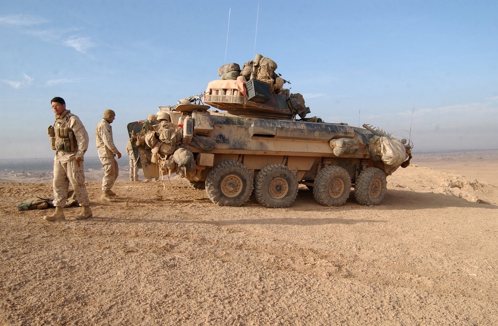 U.S. Marines take a break outside of their light armored vehicle.