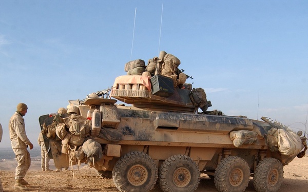 U.S. Marines take a break outside of their light armored vehicle.