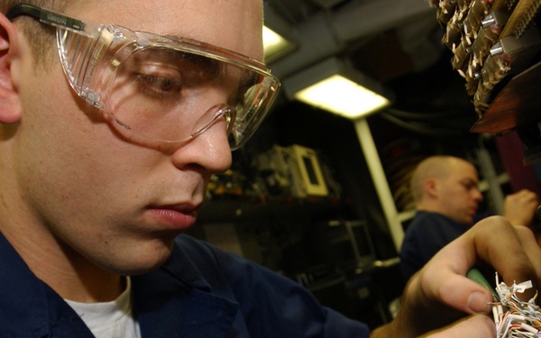 U.S. Navy Airman Marty Trojan replaces a connector on an infrared receiver.
