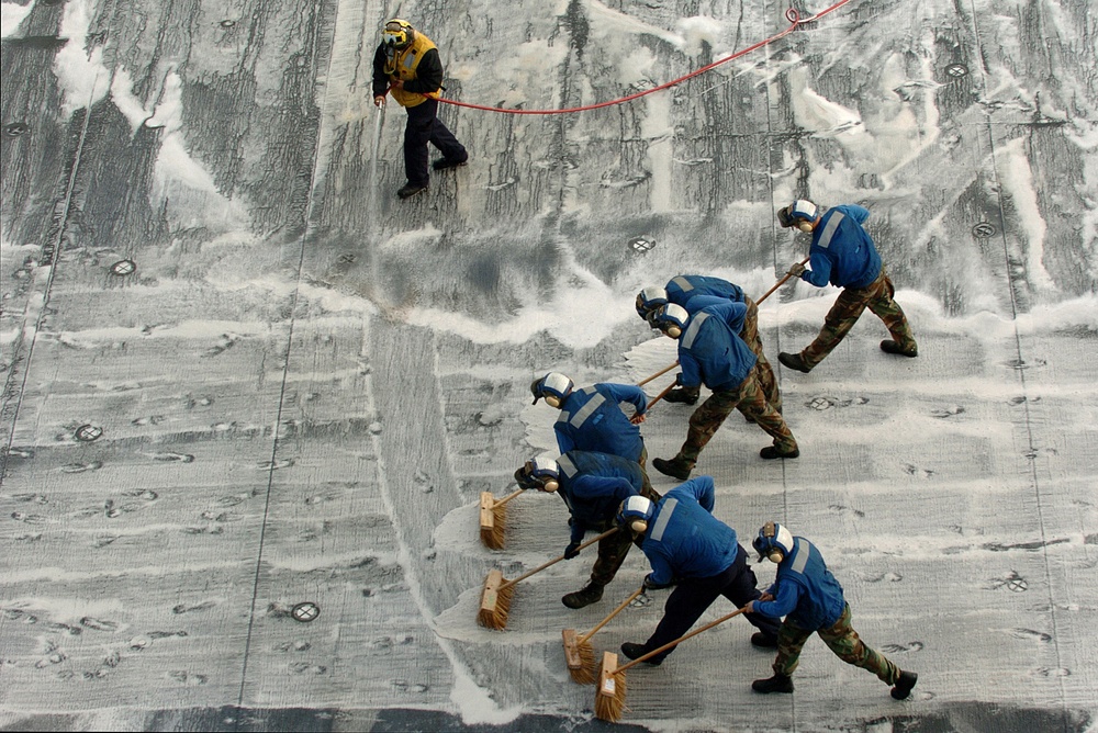 U.S. Navy aviation boatswain's mates scrub the flight deck.