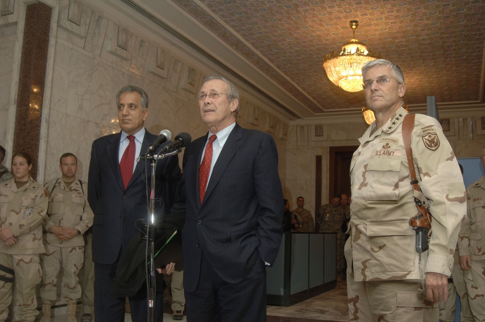 U.S. Ambassador to Iraq Zalmay Khalizad and Gen. George Casey Jr. flank Secretary Rumsfeld.