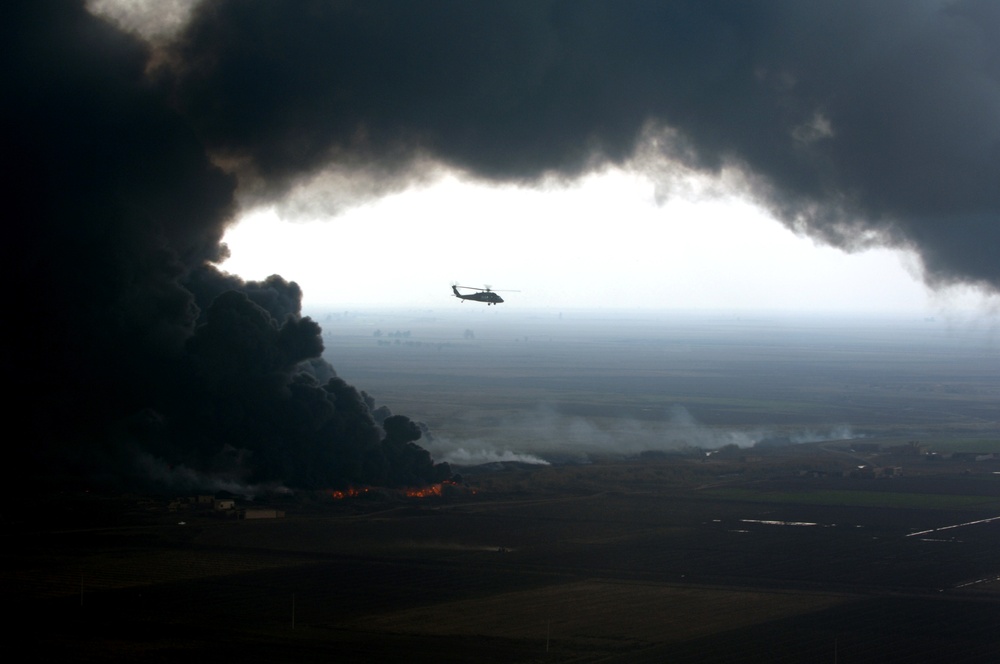 A plume of smoke surrounds a U.S. Army UH-60 Black Hawk helicopter.