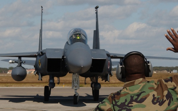 Senior Airman Chauncey Mitchell puts a little body language into it as he directs the pilot of an F-15E Strike Eagle.