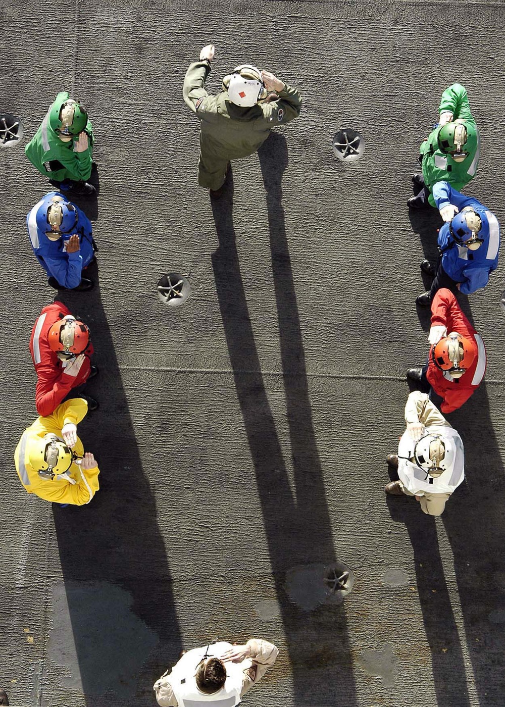 Navy side boys salute as Rear Adm. Mark T. Emerson departs the aircraft carrier USS Abraham Lincoln.