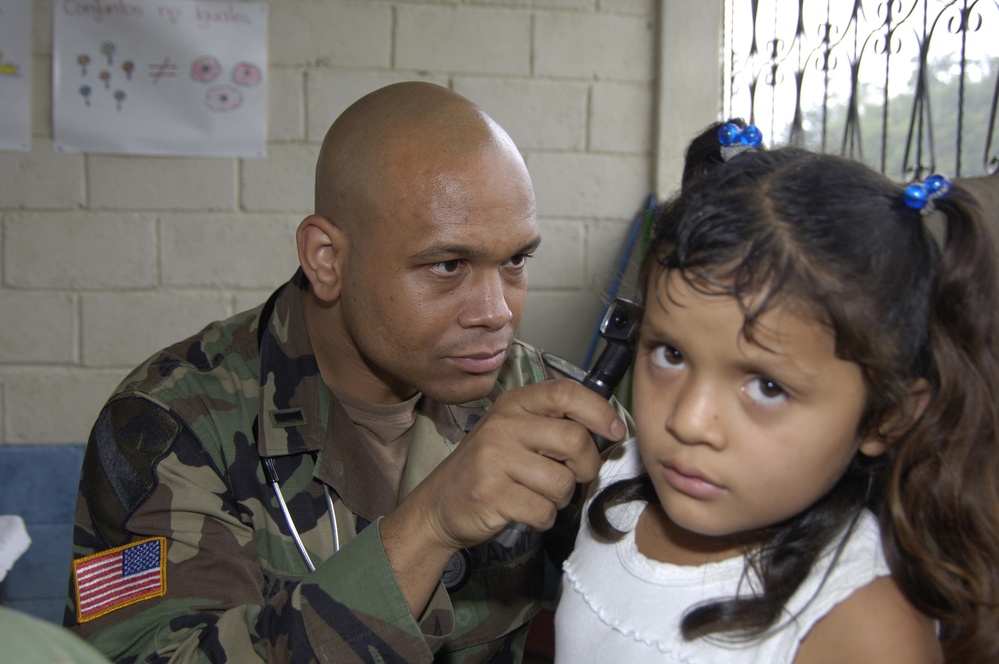 U.S. Army Physician Assistant 1st Lt. Angelo Carter examines a young Guatemalan girl.