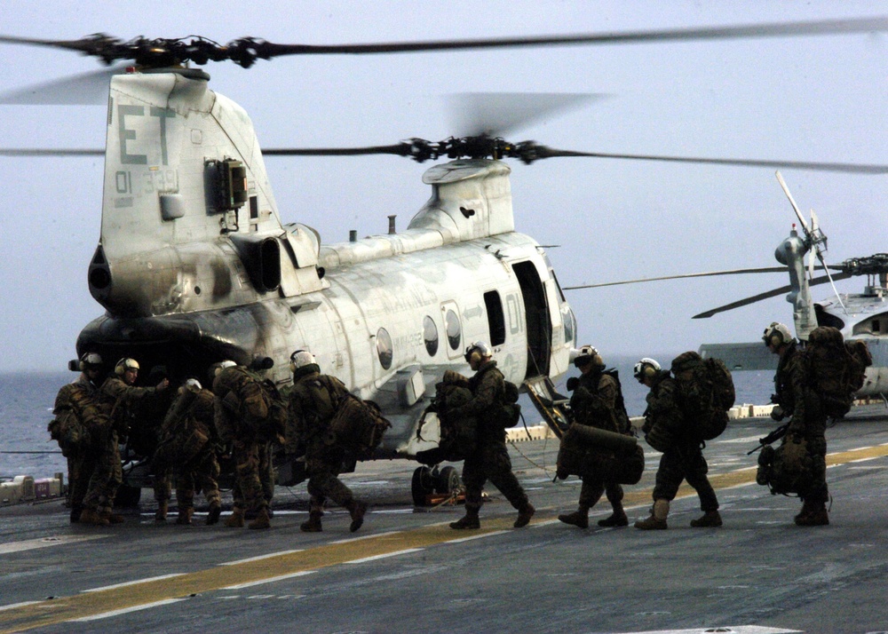 U.S. Marines board a Marine CH-46E Sea Knight helicopter.
