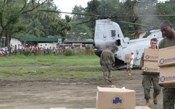U.S. Marine Staff Sgt. Jimmy Wheeler and Cpl. Joe Rainey unload supplies from a CH-46 Sea Knight.