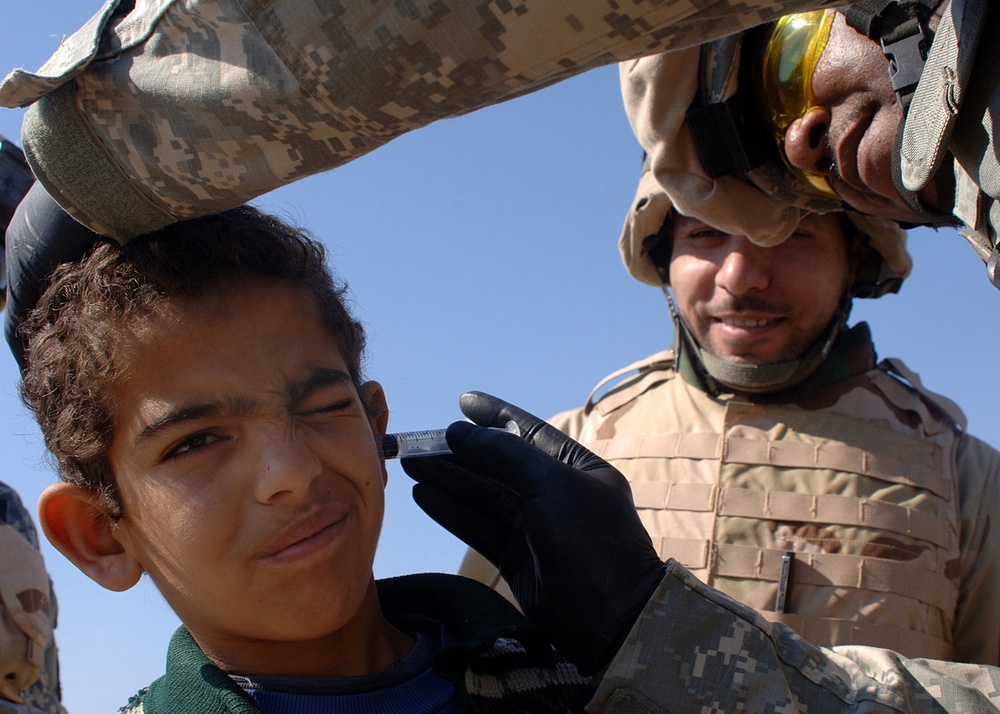U.S. Army Capt. Edward Barnes treats a six-year-old Iraqi boy.