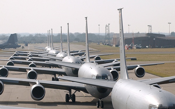 Seven U.S. Air Force KC-135 Stratotanker aircraft line up on the flight line.