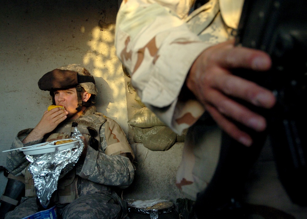 U.S. Army Pfc. Brandon Standifer eats dinner during his shift in a guard shack.