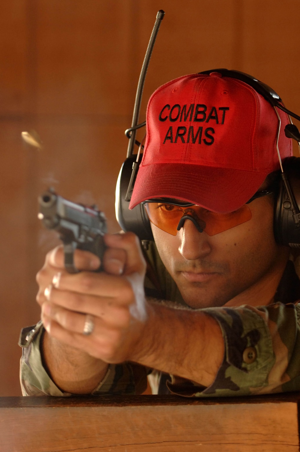 Shell casings fly as Air Force Staff Sgt. Christopher Oshana fires an M-9 handgun.