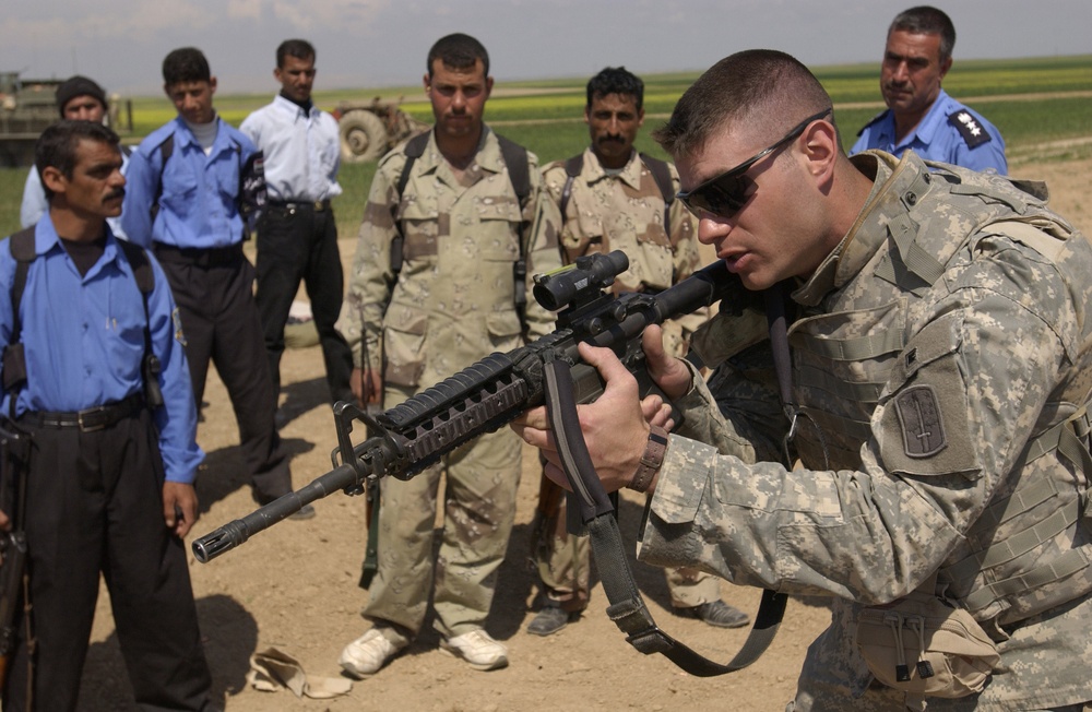 Sgt. Nicholas Sowinski demonstrates shooting techniques to Iraqi police officers.