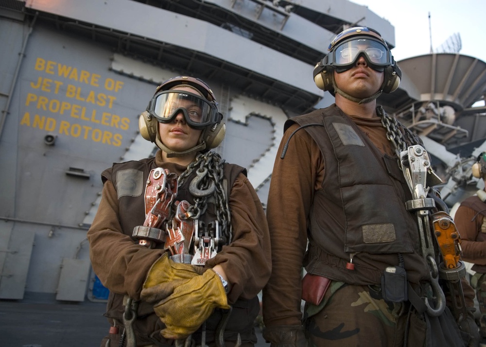 U.S. Navy plane captains stand by as their aircraft are launched.