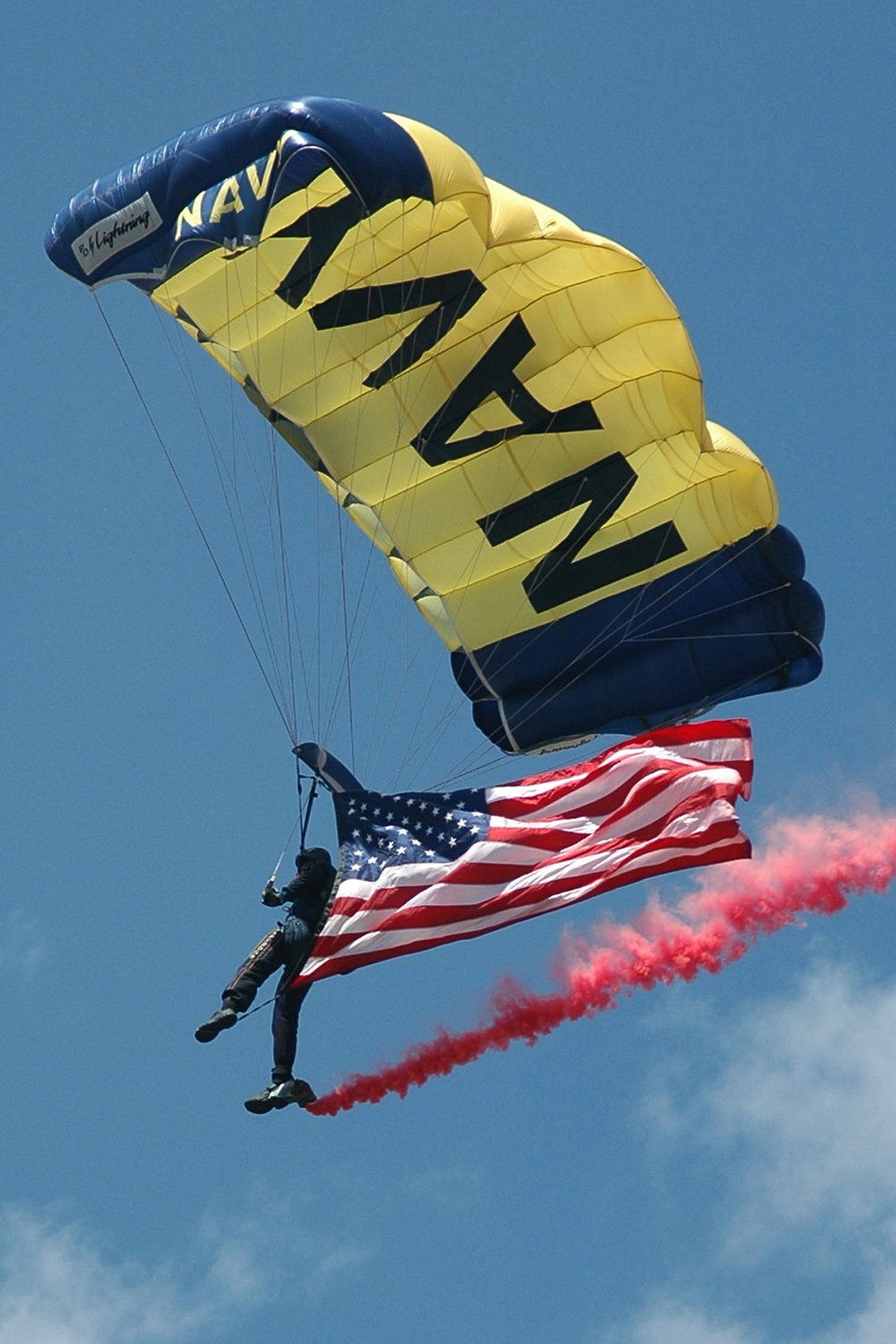 A sailor with the U.S. Navy's parachute demonstration team descends from the sky.