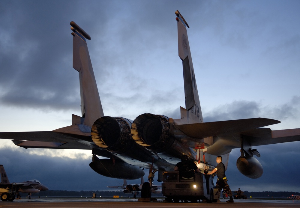 A weapons loading team attaches an AIM-7M Sparrow missile on an F-15C Eagle.
