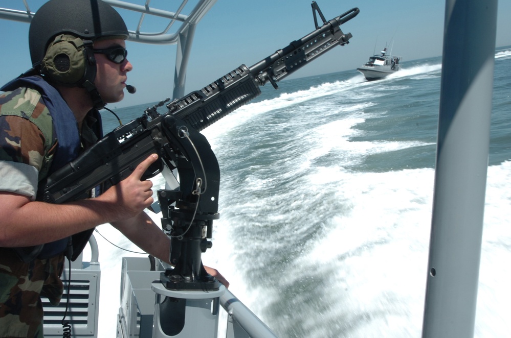 Petty Officer 3rd Class Matthew Kaczynski mans a .50-caliber machine gun.
