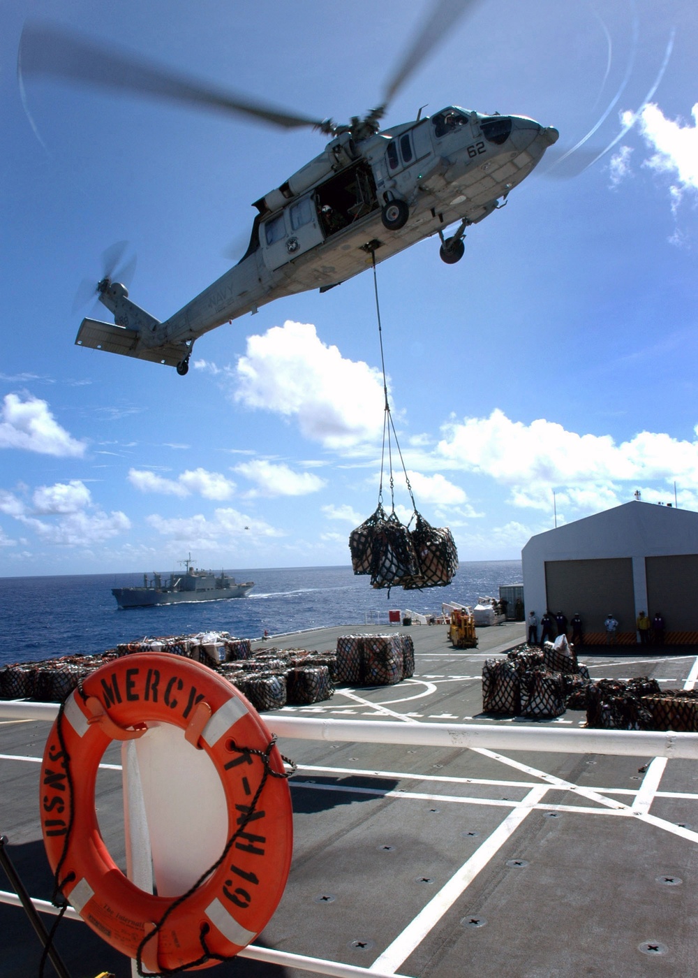An MH-60S Seahawk helicopter delivers supplies.