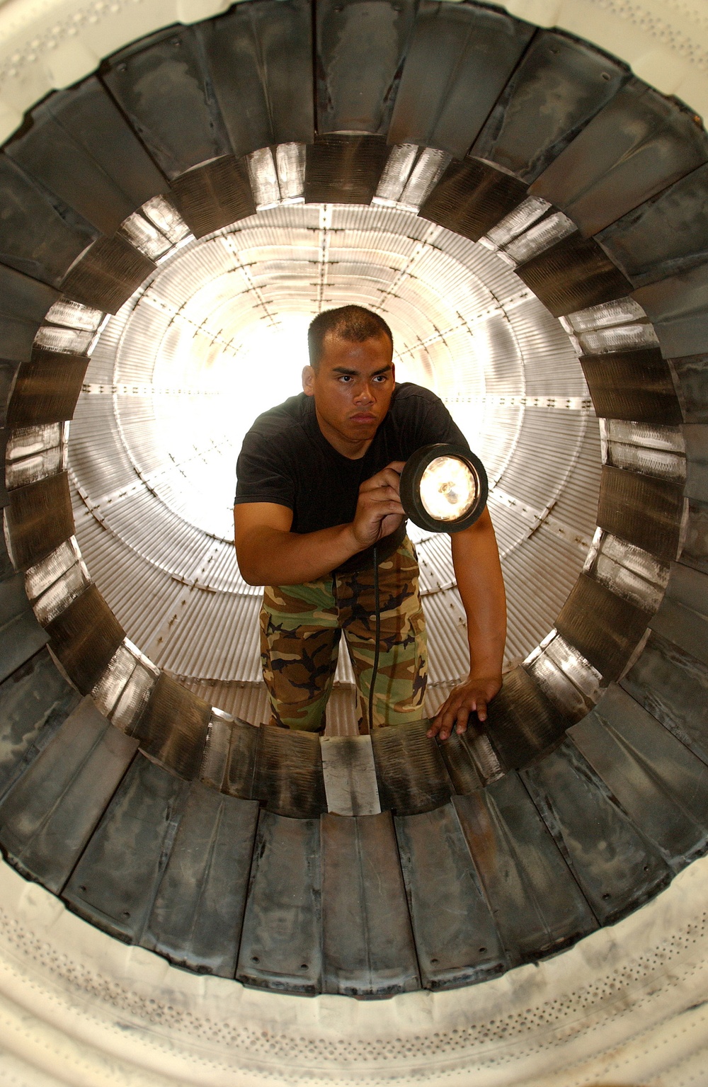 Staff Sgt. Randy James inspects the augmenter section of an F100-PW-229 jet engine.