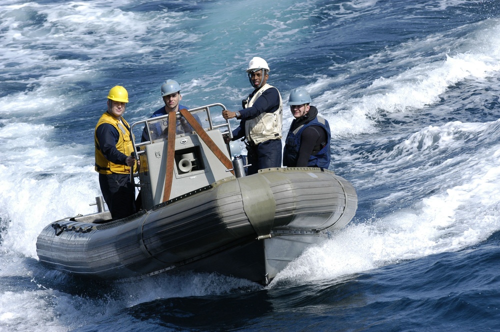 Sailors head back to their ship in a rigid-hull inflatable boat.