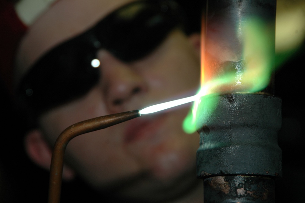 U.S. Navy Fireman Bob Chambers uses a brazing torch.