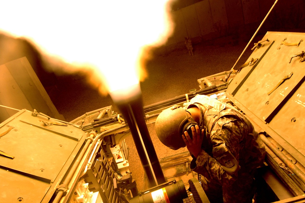 An Army soldier holds his ears as he uses a 120mm Mortar Cannon.