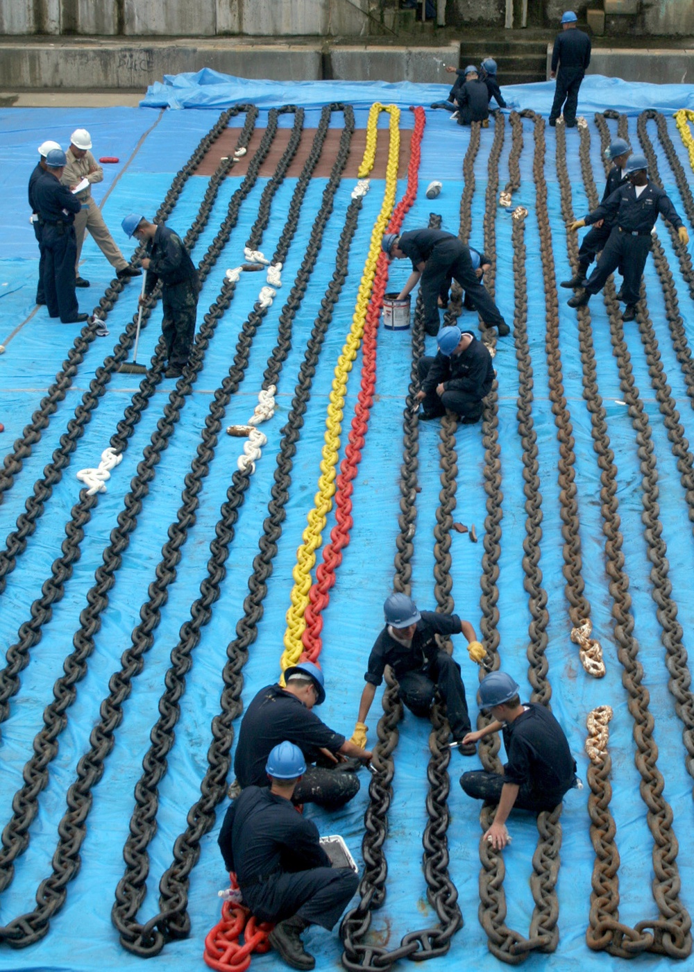 U.S. Navy sailors paint the anchor chains of the guided-missile destroyer USS Stethem (DDG 63).