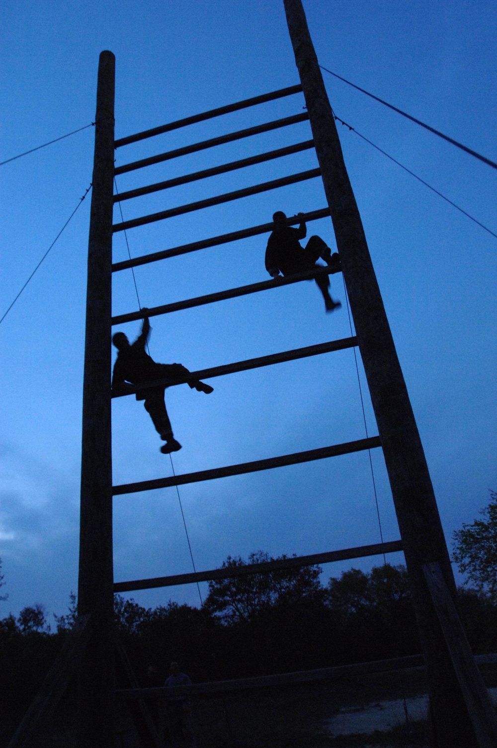 Two pararescue trainees run through an obstacle course.