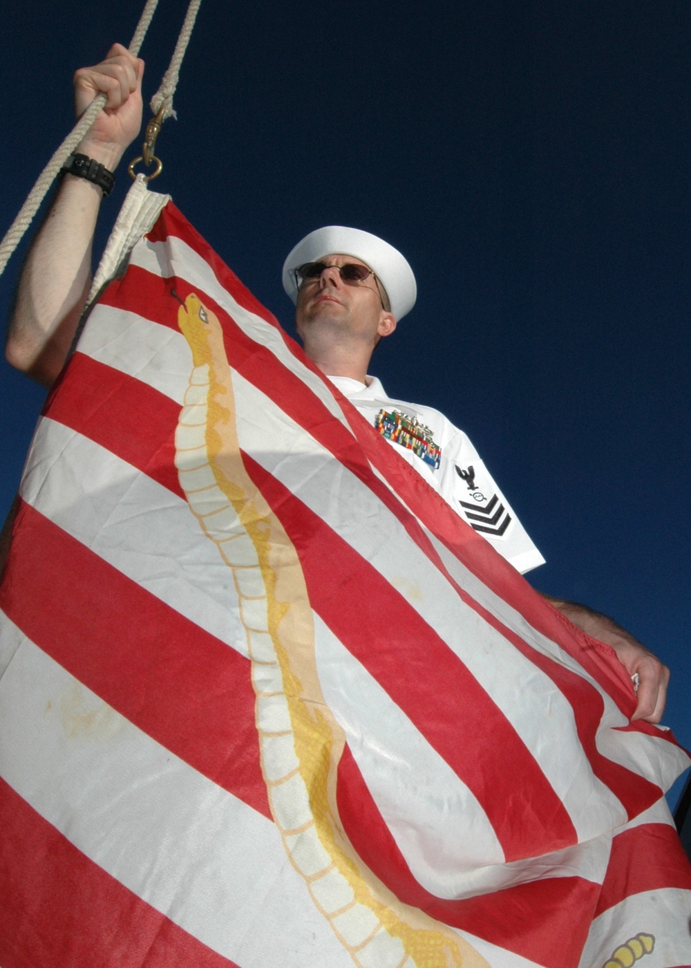 Petty Officer 1st Class Stephen Cornell prepares to raise the Navy Jack.